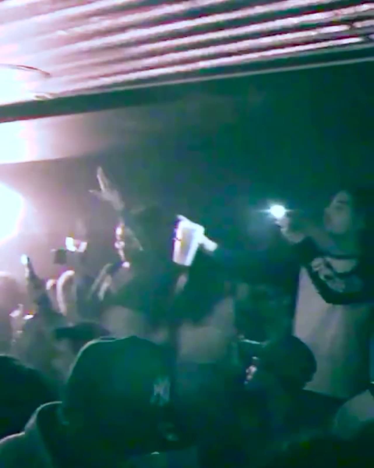 A packed night at Baby's on Queen West, hands up under the slatted light ceiling