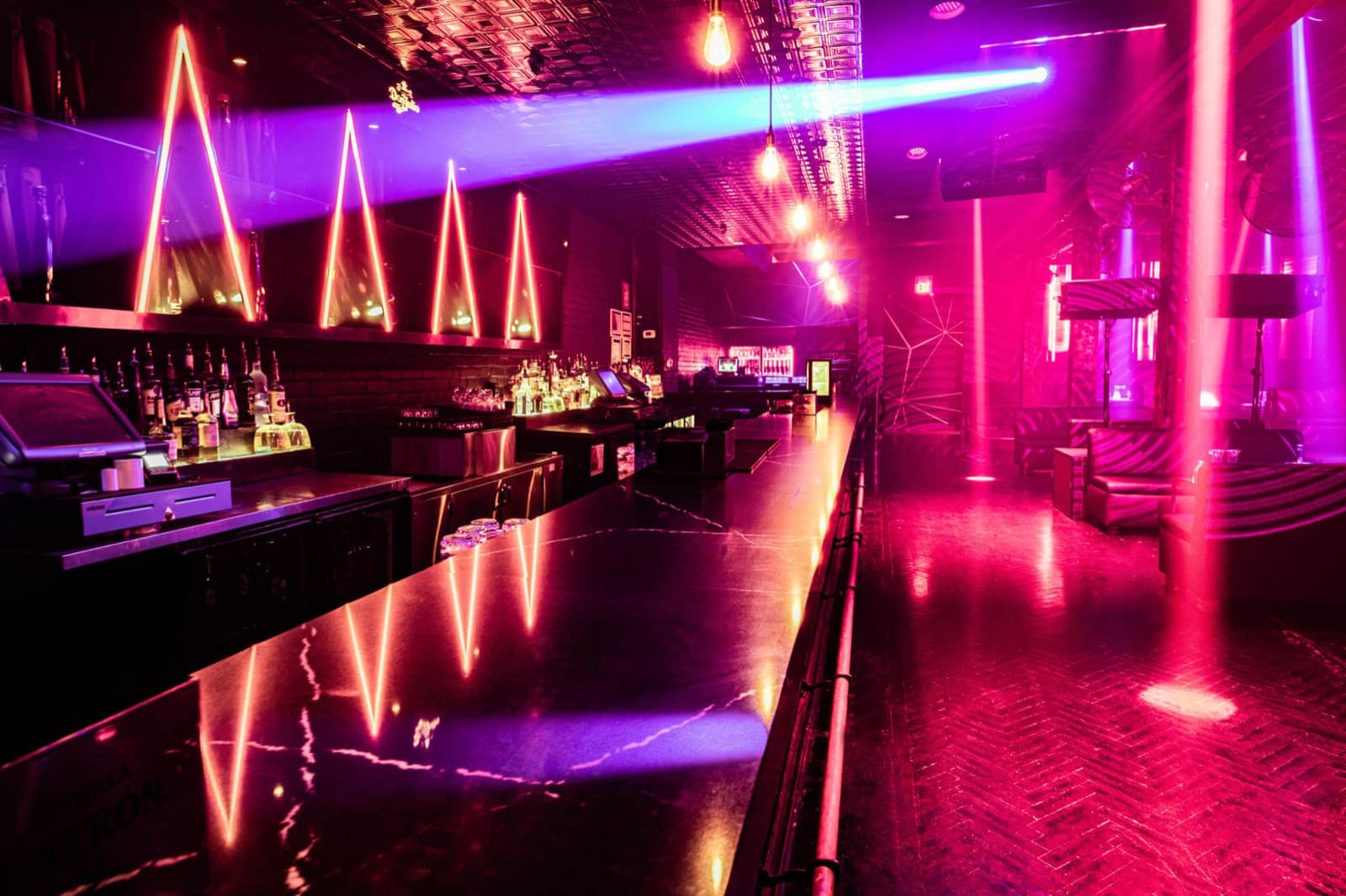 Century's main room, the long bar under pink and violet light