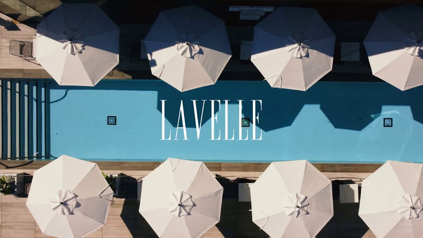Lavelle's rooftop pool from above, ringed by white umbrellas