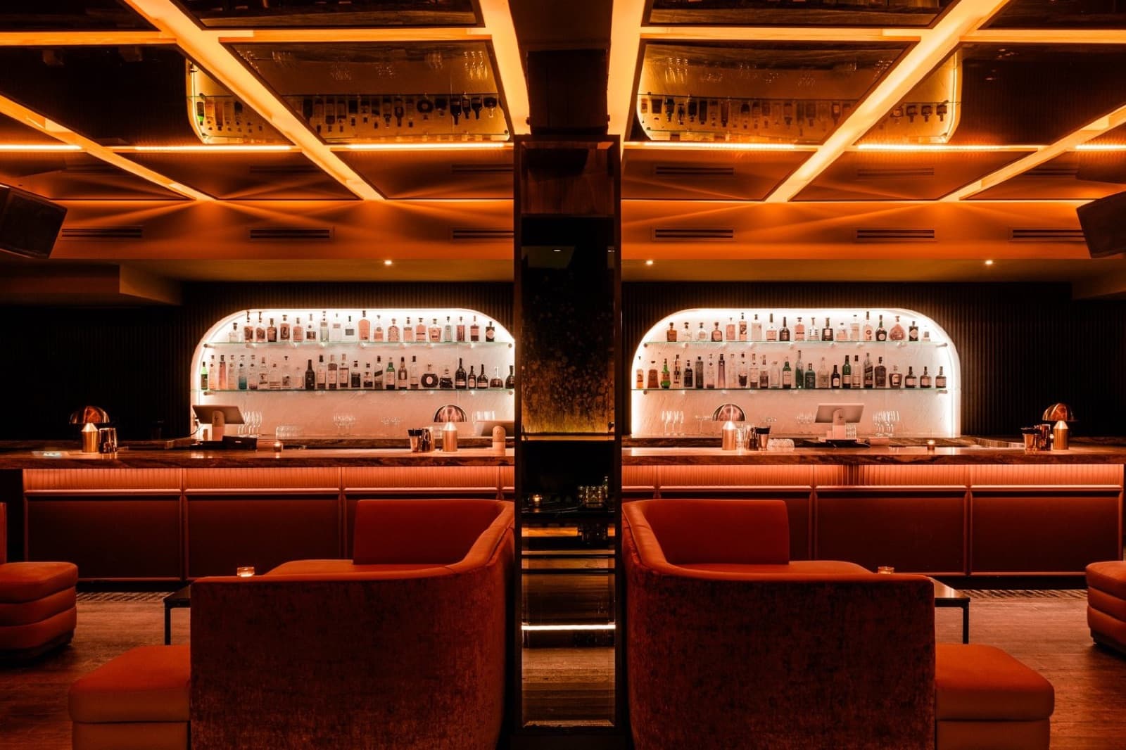 Red booths facing Parc Ave's white back bar under a lit ceiling grid