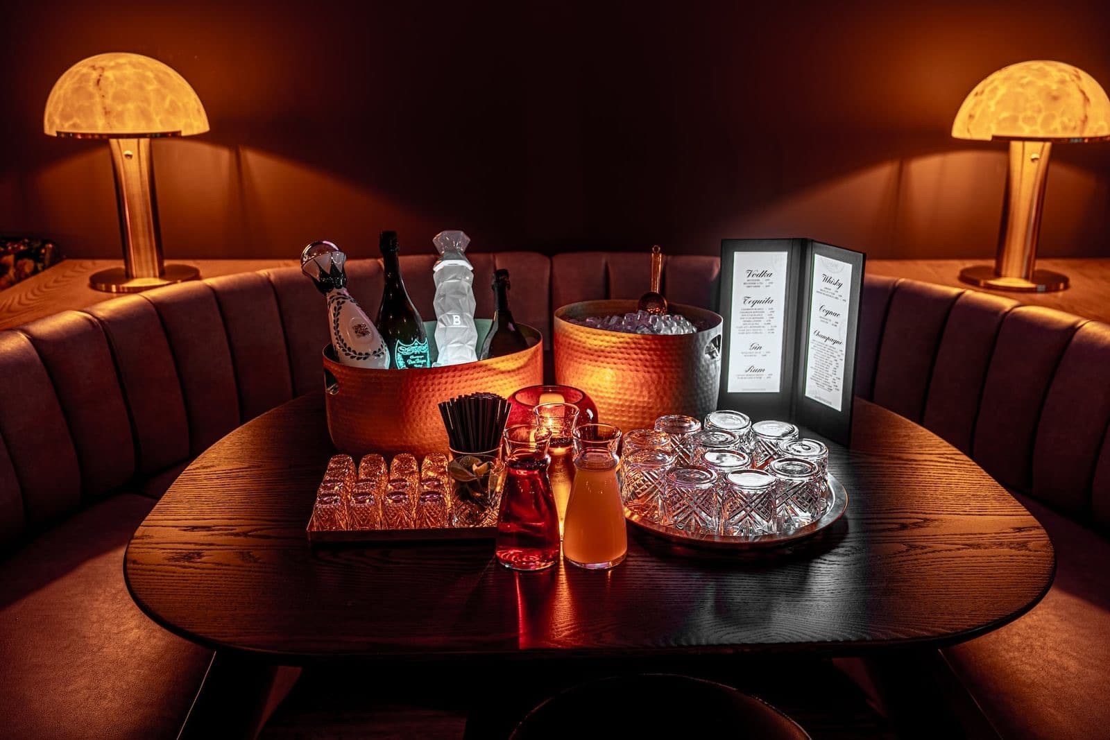 A booth at Powder Room under fringed lamps