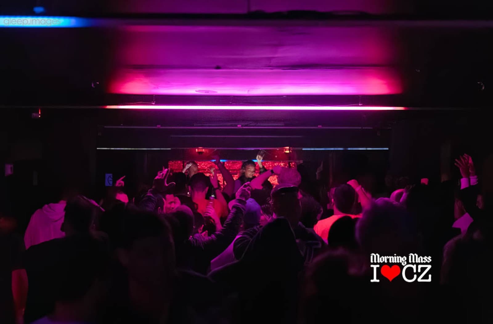 A crowded dance floor under pink and red lights at The Comfort Zone