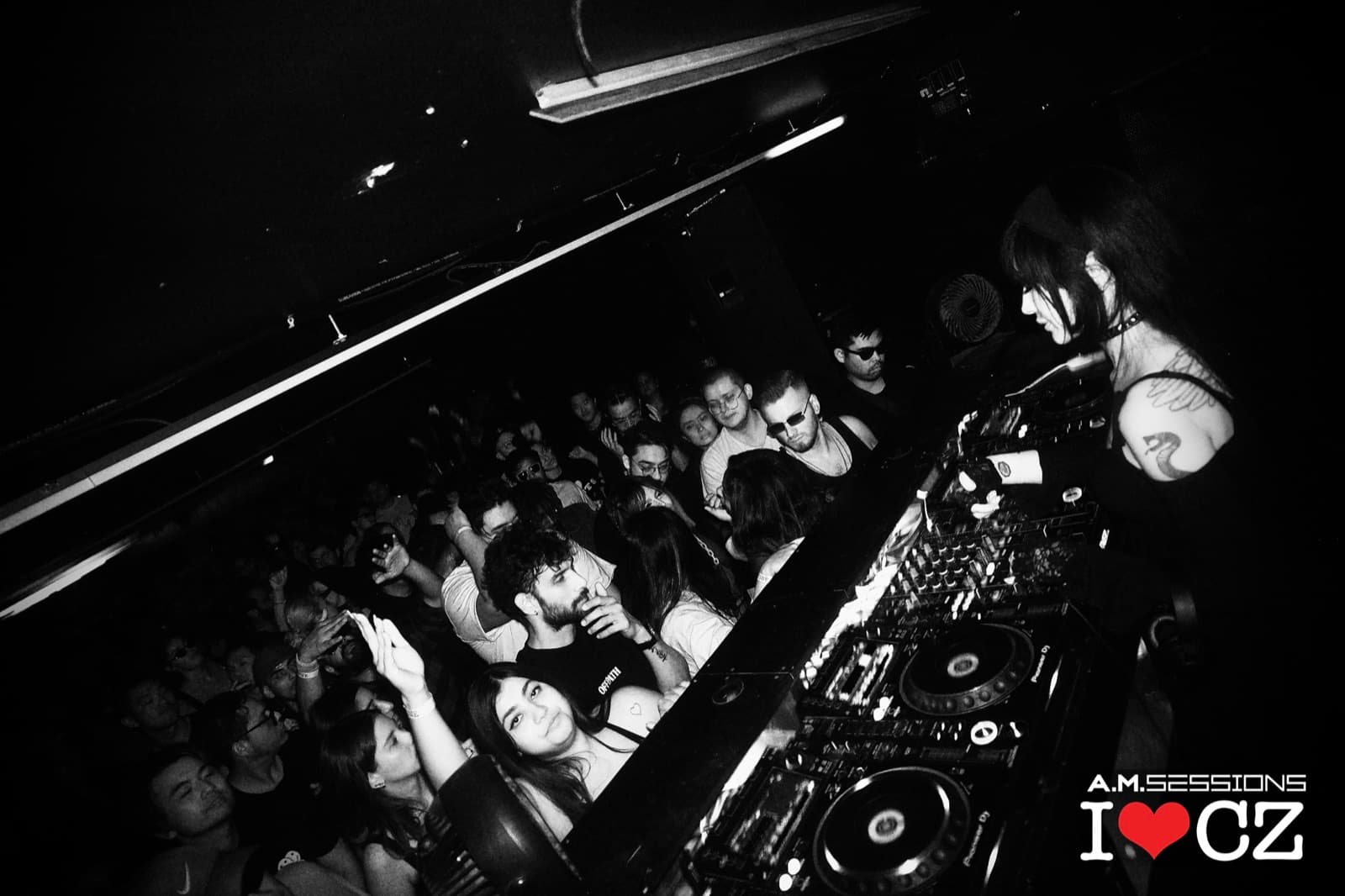 A black-and-white view from the DJ booth over a packed crowd at The Comfort Zone