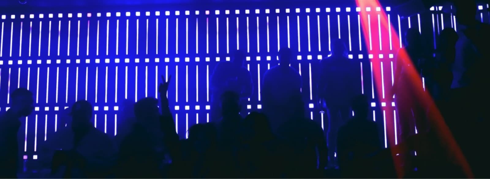 Crowd silhouettes in front of Ultraviolet's LED light wall
